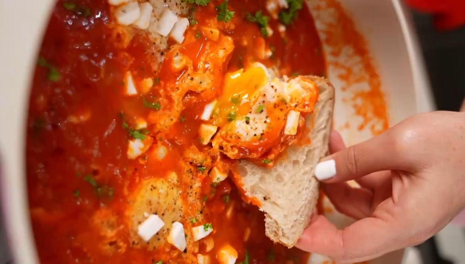 Easy shakshuka with Mamita Hot Sauce cooked in a skillet with eggs and tomato sauce